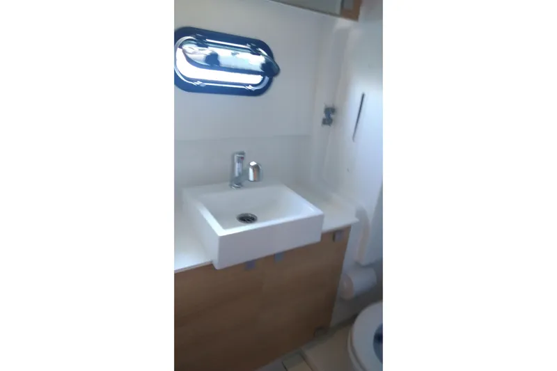 Double Kiss Yacht Photos Pics Compact bathroom in 2018 Bali 4.1 model, featuring a modern sink and porthole window.