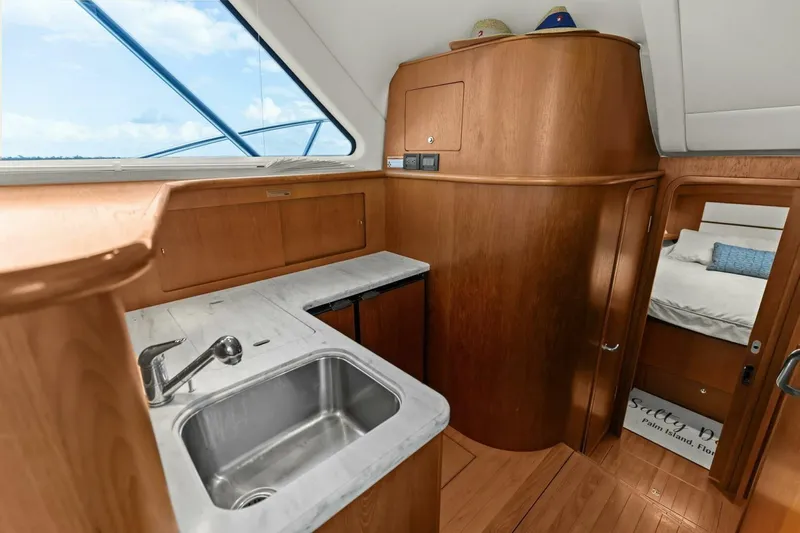 Salty Dach Yacht Photos Pics 2013 Tiara Yachts 3900 Convertible interior with wooden cabinetry and stainless steel sink.