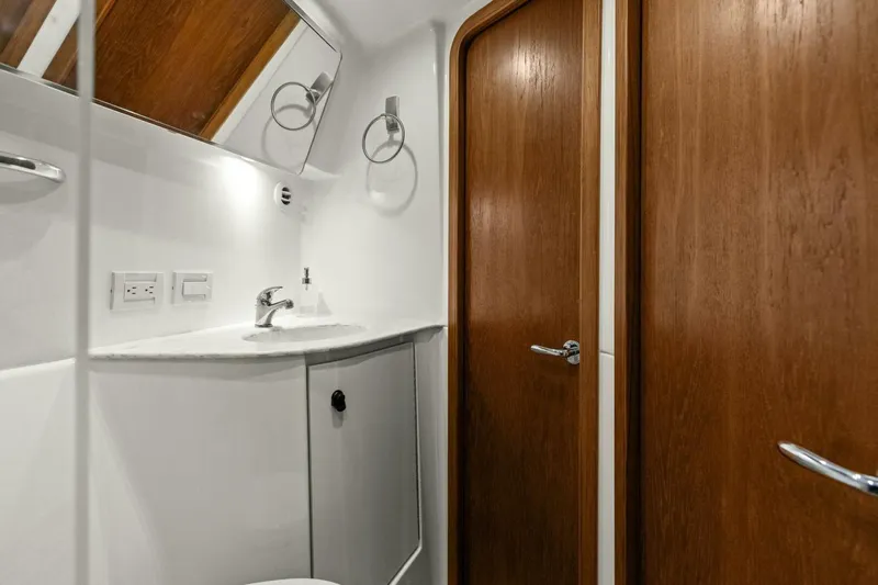 Salty Dach Yacht Photos Pics Luxurious bathroom interior of 2013 Tiara Yachts 3900 Convertible, featuring wood accents and modern fixtures.