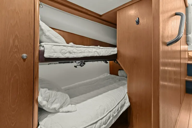 Salty Dach Yacht Photos Pics Bunk beds in 2013 Tiara Yachts 3900 Convertible, featuring wooden interior and cozy bedding.