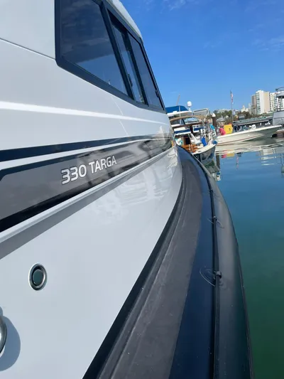 Maneki Neko Yacht Photos Pics Protector 330 Targa boat docked, showcasing sleek design and modern features.