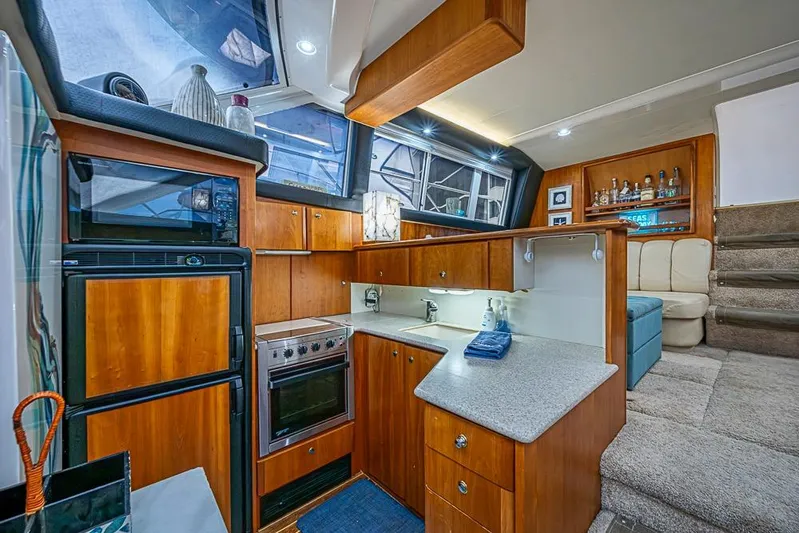 Faintasea Yacht Photos Pics Interior of 2000 Silverton 442 Cockpit Motor Yacht with modern kitchen and seating area.