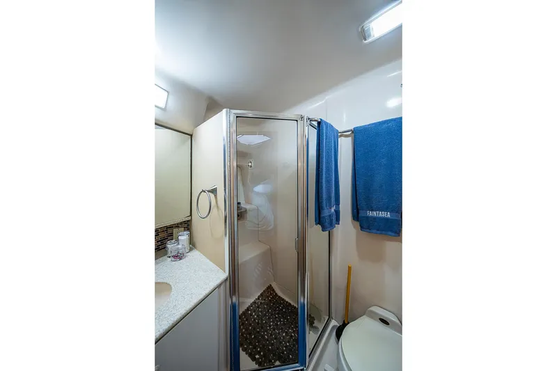 Faintasea Yacht Photos Pics Bathroom interior of 2000 Silverton 442 Cockpit Motor Yacht with shower and blue towels.