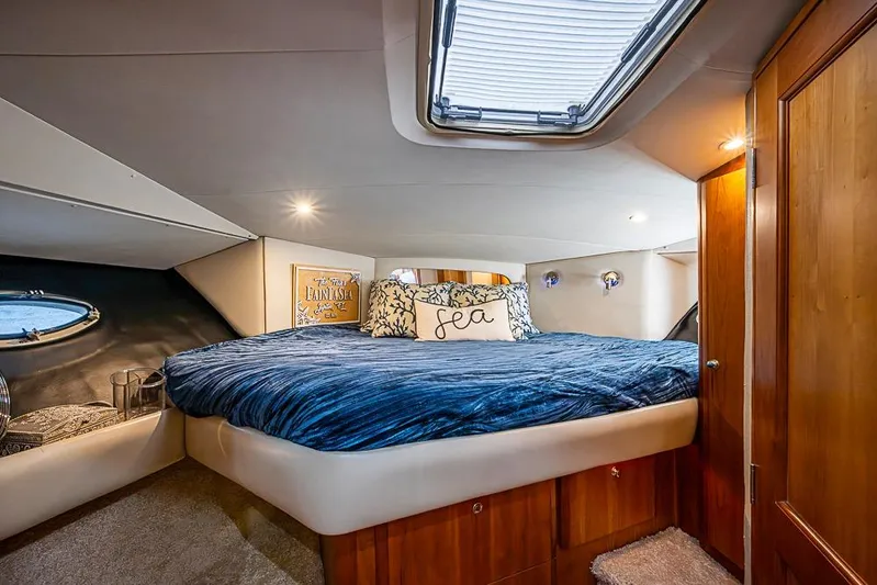 Faintasea Yacht Photos Pics Luxurious bedroom interior of 2000 Silverton 442 Cockpit Motor Yacht with skylight and cozy bedding.