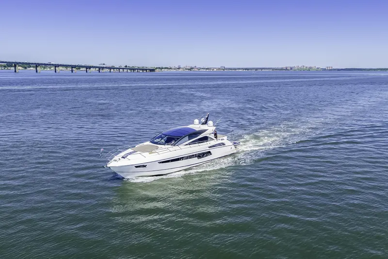  Yacht Photos Pics 2014 Sunseeker 68 Sport Yacht cruising on open water under clear blue sky.
