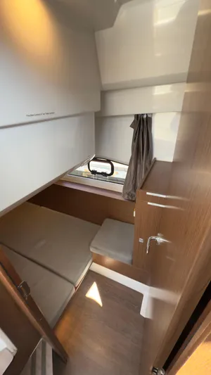  Yacht Photos Pics 2019 Jeanneau NC Weekender 1095 cabin interior with bed, window, and wooden accents.