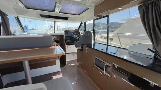  Yacht Photos Pics Interior of 2019 Jeanneau NC Weekender 1095, featuring modern helm and galley area.