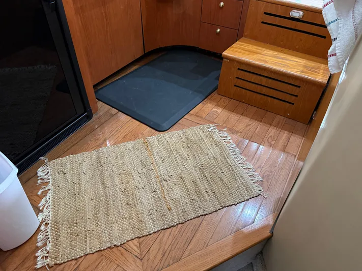 Jet Lag Yacht Photos Pics Interior of 1999 Sea Ray 400 Sedan Bridge with wooden flooring and woven rug.
