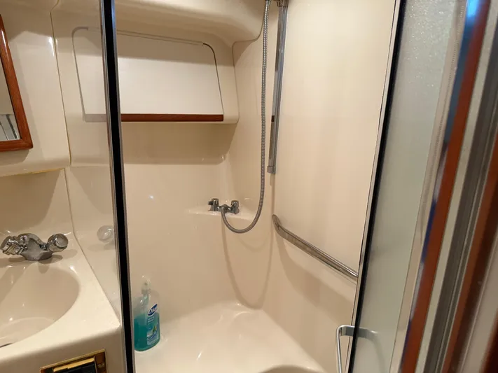 Jet Lag Yacht Photos Pics Bathroom interior of 1999 Sea Ray 400 Sedan Bridge yacht, featuring shower and sink.