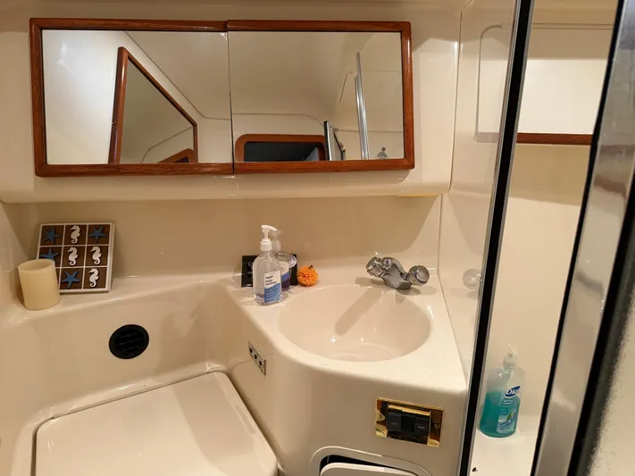 Jet Lag Yacht Photos Pics Bathroom interior of 1999 Sea Ray 400 Sedan Bridge yacht, featuring sink and mirror.