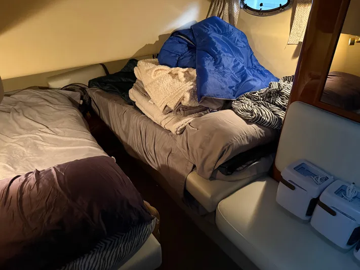 Jet Lag Yacht Photos Pics Interior cabin of 1999 Sea Ray 400 Sedan Bridge with cozy bedding and porthole window.