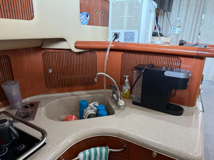 Jet Lag Yacht Photos Pics 1999 Sea Ray 400 Sedan Bridge kitchen with sink, coffee maker, and wooden cabinetry.