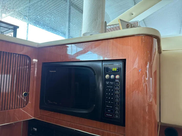 Jet Lag Yacht Photos Pics 1999 Sea Ray 400 Sedan Bridge interior with Panasonic microwave in wooden cabinetry.