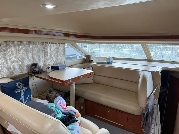 Jet Lag Yacht Photos Pics Interior of 1999 Sea Ray 400 Sedan Bridge with beige seating and table.