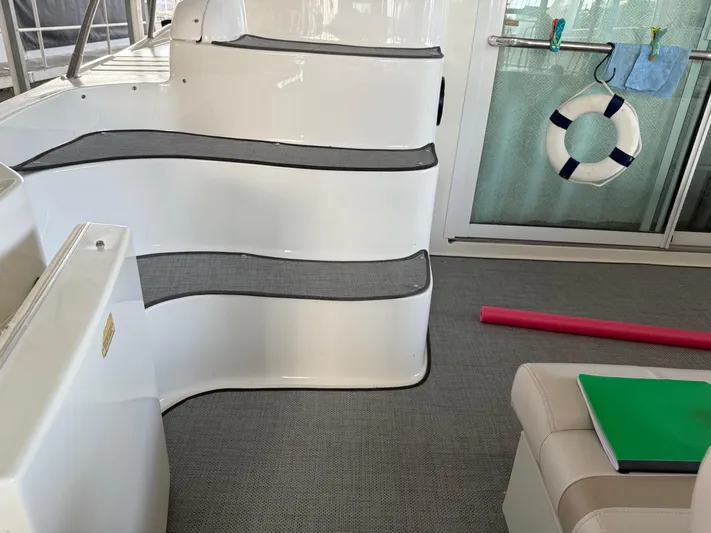 Jet Lag Yacht Photos Pics 1999 Sea Ray 400 Sedan Bridge interior with steps, life preserver, and seating area.