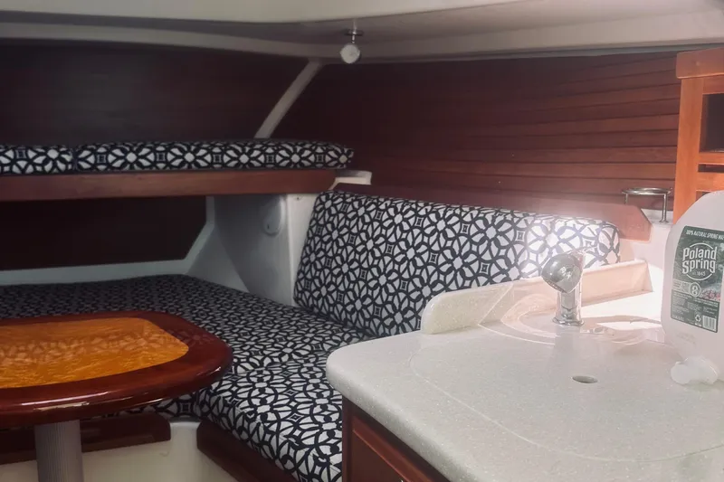 Sister's Yacht Photos Pics 2013 Back Cove 30 interior with patterned seating, wooden table, and compact sink area.