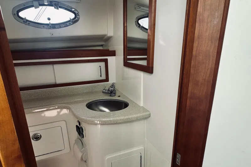Sister's Yacht Photos Pics 2013 Back Cove 30 yacht bathroom with sink, mirror, and wooden accents.