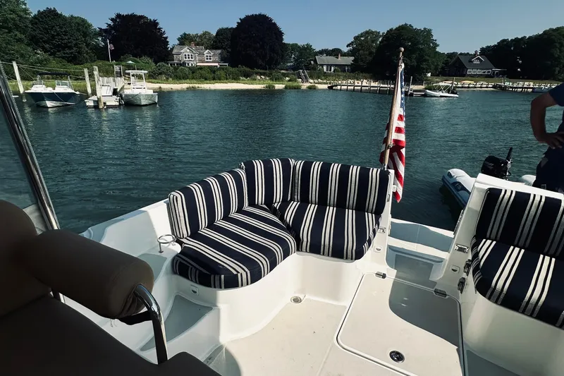 Sister's Yacht Photos Pics 2013 Back Cove 30 boat with striped seating, docked in a scenic marina.