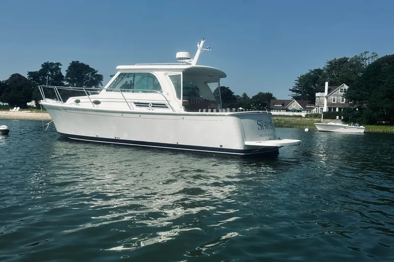 Sister's Yacht Photos Pics 2013 Back Cove 30 boat on calm water near shoreline homes.