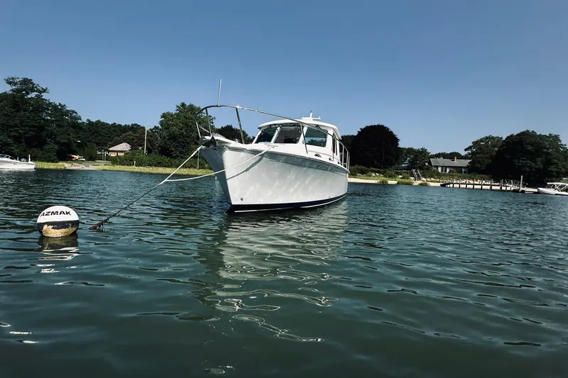 Sister's Yacht Photos Pics 2013 Back Cove 30 boat anchored in calm waters near a scenic shoreline.