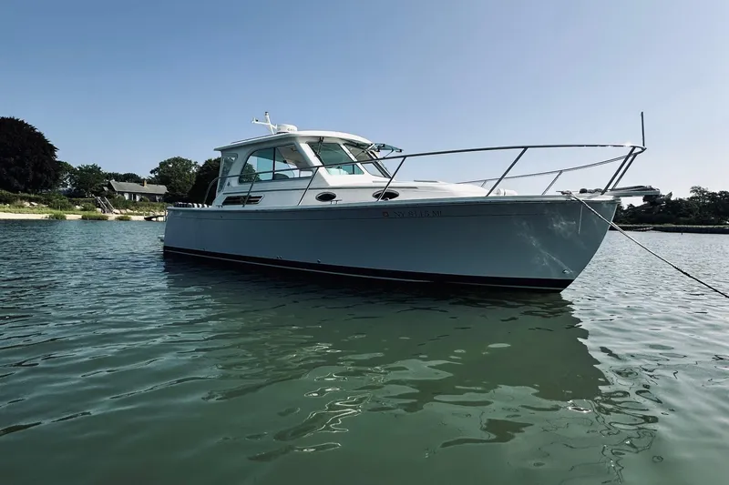 Sister's Yacht Photos Pics 2013 Back Cove 30 boat anchored on calm water under clear blue sky.