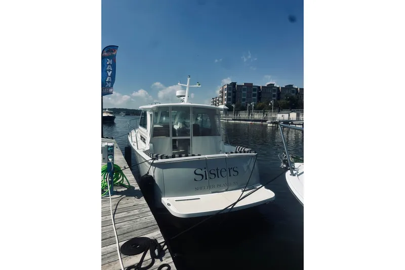 Sister's Yacht Photos Pics 2013 Back Cove 30 boat docked at marina, clear sky, waterfront buildings.