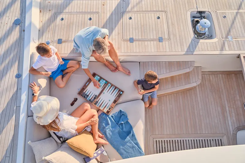  Yacht Photos Pics Family playing backgammon on 2023 Lagoon Seventy 7 yacht deck.