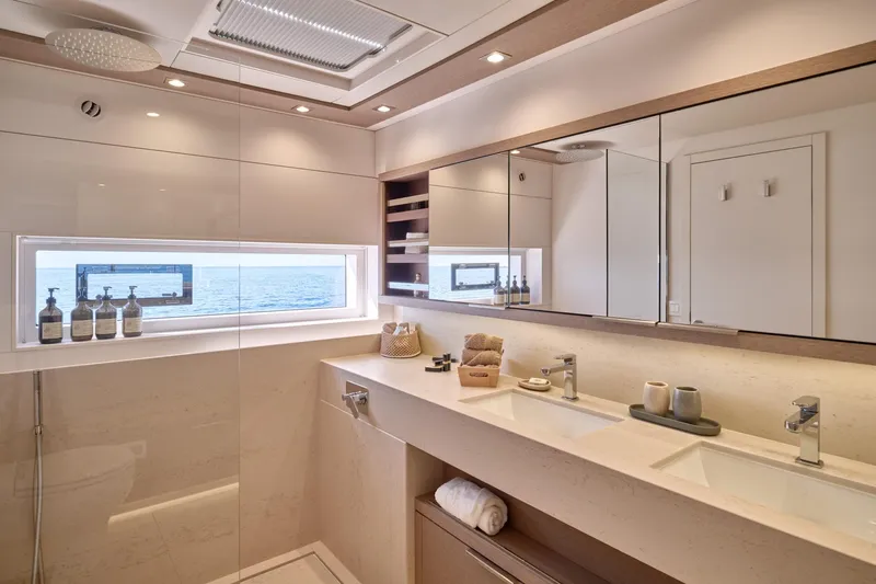  Yacht Photos Pics Luxurious bathroom interior of 2023 Lagoon Seventy 7 yacht with ocean view window.