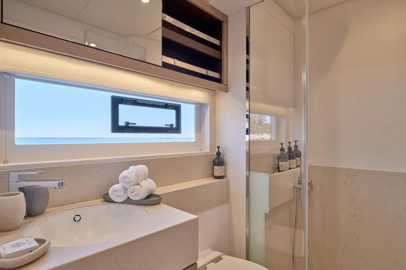  Yacht Photos Pics Luxurious bathroom in 2023 Lagoon Seventy 7 yacht with ocean view window.