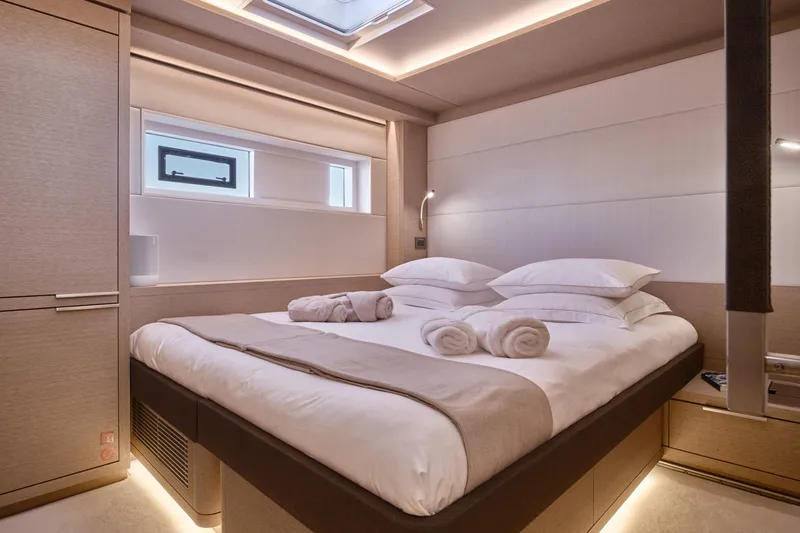  Yacht Photos Pics Luxurious bedroom interior of 2023 Lagoon Seventy 7 yacht with elegant lighting and modern design.