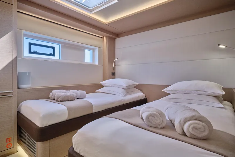  Yacht Photos Pics Luxurious cabin interior of 2023 Lagoon Seventy 7 yacht with twin beds and modern decor.