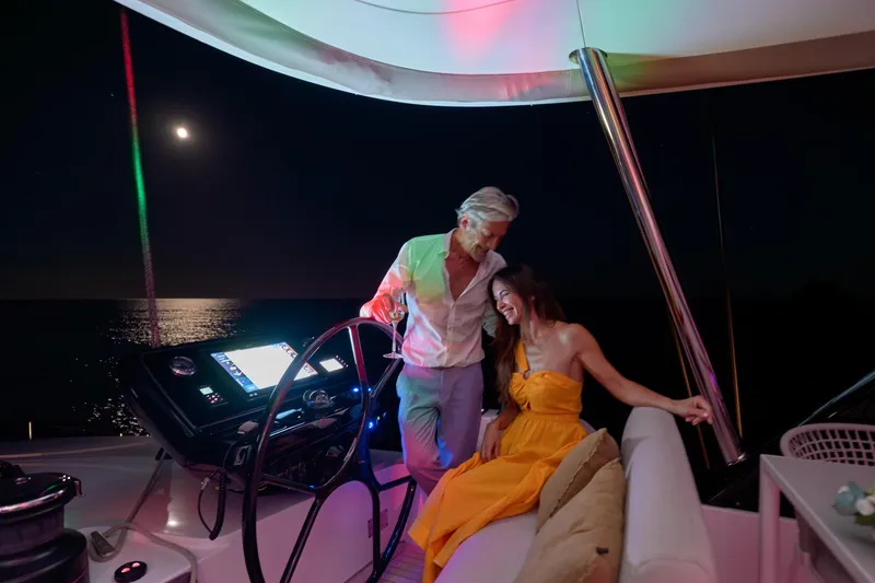  Yacht Photos Pics Couple enjoying a moonlit night on a 2023 Lagoon Seventy 7 yacht.