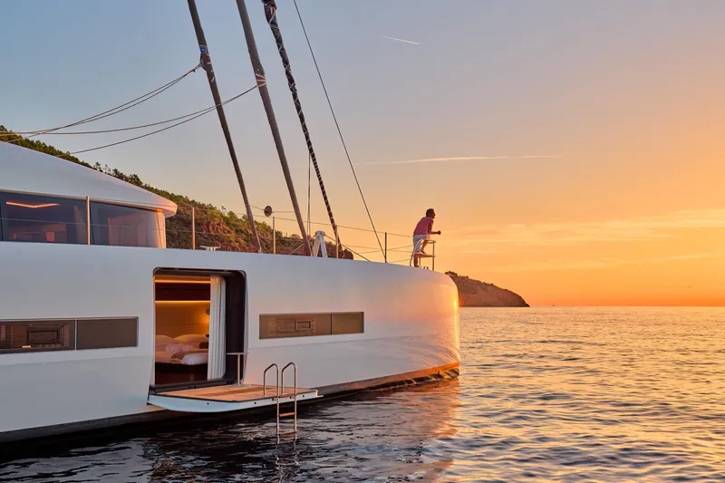  Yacht Photos Pics 2023 Lagoon Seventy 7 yacht at sunset, person enjoying ocean view.