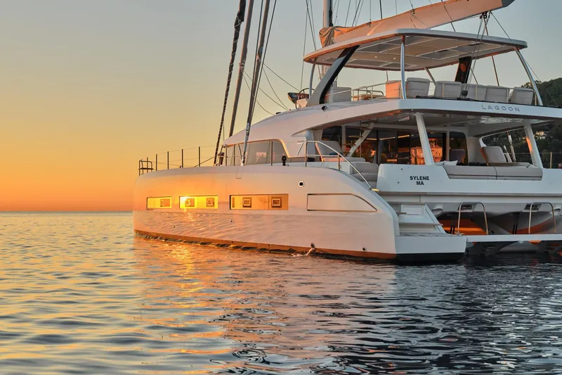  Yacht Photos Pics 2023 Lagoon Seventy 7 yacht at sunset on calm waters.