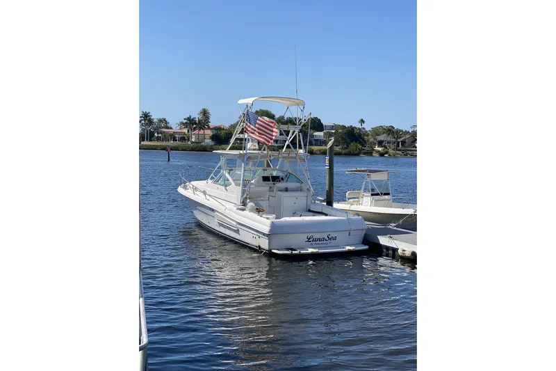  Yacht Photos Pics 2005 Stamas 370 Express boat docked, featuring an American flag and calm waters.