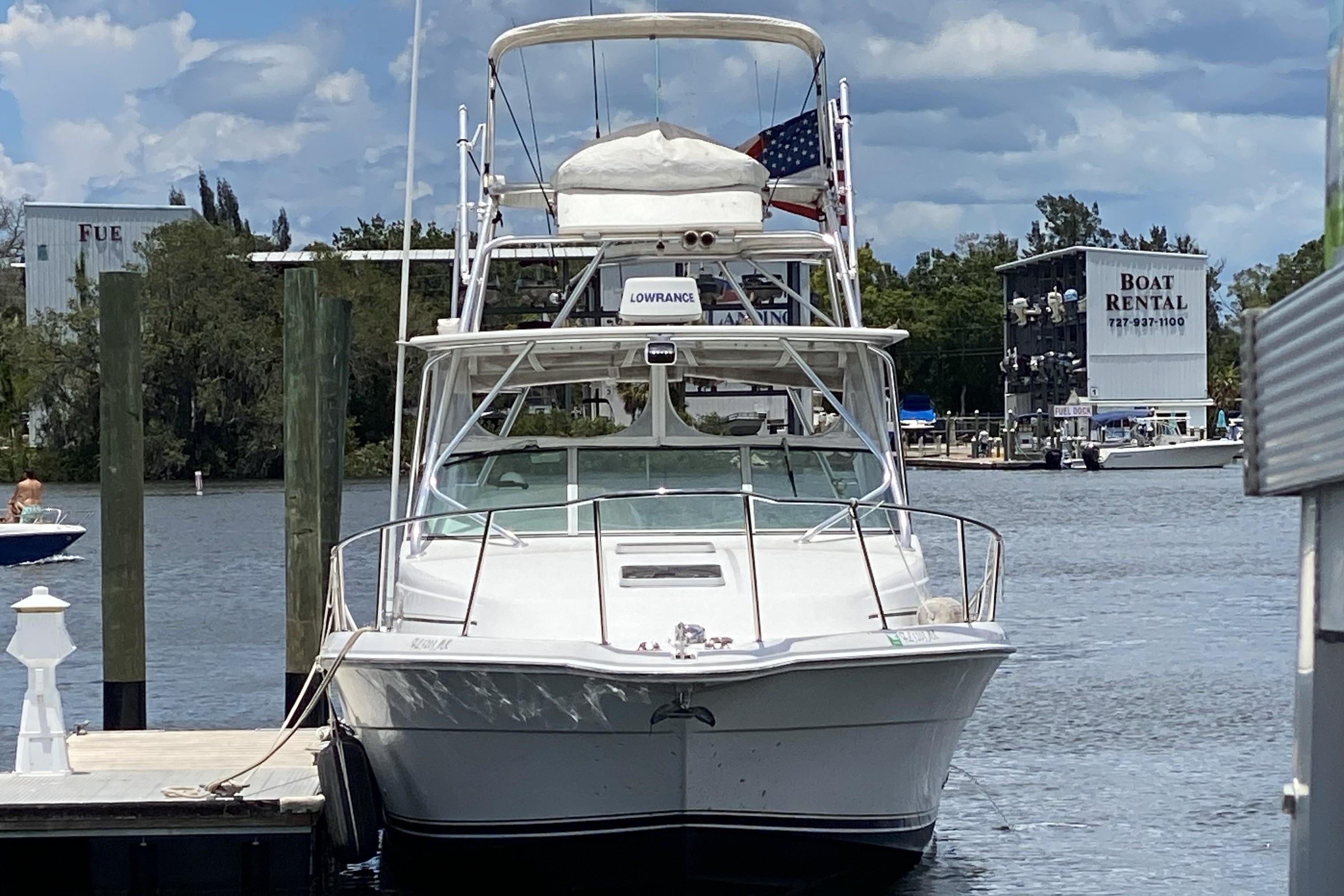 2005 Stamas 370 Express boat docked at marina with rental services in background.