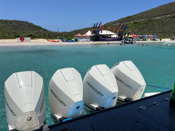  Yacht Photos Pics Four Mercury outboard engines on a 2021 Boston Whaler 405 Conquest near a scenic beach.