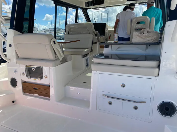  Yacht Photos Pics 2021 Boston Whaler 405 Conquest interior with seating and storage, docked under a clear sky.