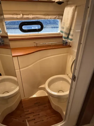 Andiamo Yacht Photos Pics Interior of 2016 Sea Ray 350 Sundancer bathroom with wooden accents and porthole window.