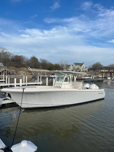  Yacht Photos Pics 2022 Sailfish 290cc boat docked in a marina under a clear blue sky.
