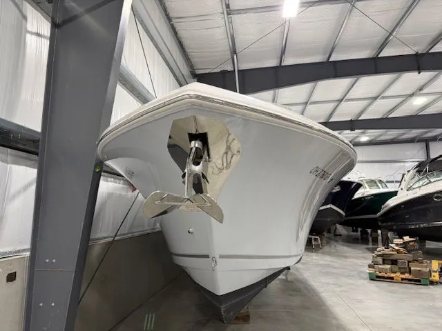  Yacht Photos Pics 2022 Sailfish 290cc boat in indoor storage, showcasing sleek design and anchor.