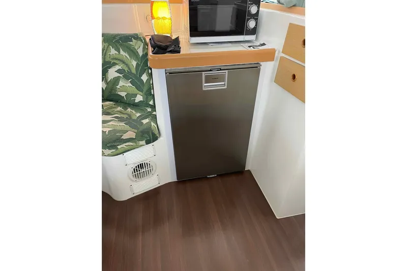 Apres-sea Yacht Photos Pics Interior of 2012 Lagoon 380 S2 yacht with fridge, microwave, and tropical-patterned seating.