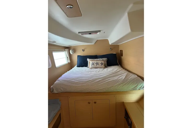 Apres-sea Yacht Photos Pics Cozy cabin interior of 2012 Lagoon 380 S2 catamaran with bed and porthole window.