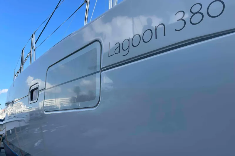 Apres-sea Yacht Photos Pics Side view of a 2012 Lagoon 380 S2 catamaran against a clear blue sky.