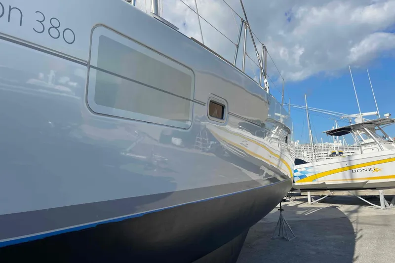 Apres-sea Yacht Photos Pics 2012 Lagoon 380 S2 catamaran docked beside a Donzi boat under a blue sky.