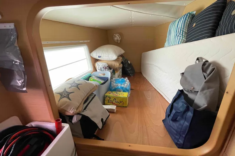 Apres-sea Yacht Photos Pics Cozy cabin interior of 2012 Lagoon 380 S2 with pillows, bags, and supplies.