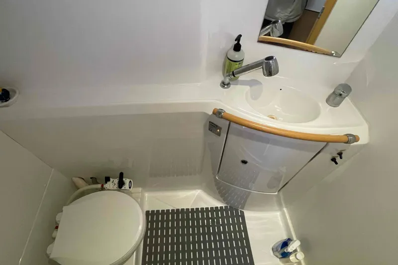 Apres-sea Yacht Photos Pics Compact bathroom in 2012 Lagoon 380 S2 yacht with sink, toilet, and mirror.