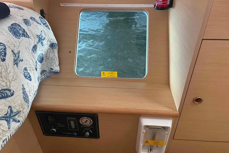 Apres-sea Yacht Photos Pics Interior of 2012 Lagoon 380 S2 yacht with window, control panel, and nautical-themed bedding.