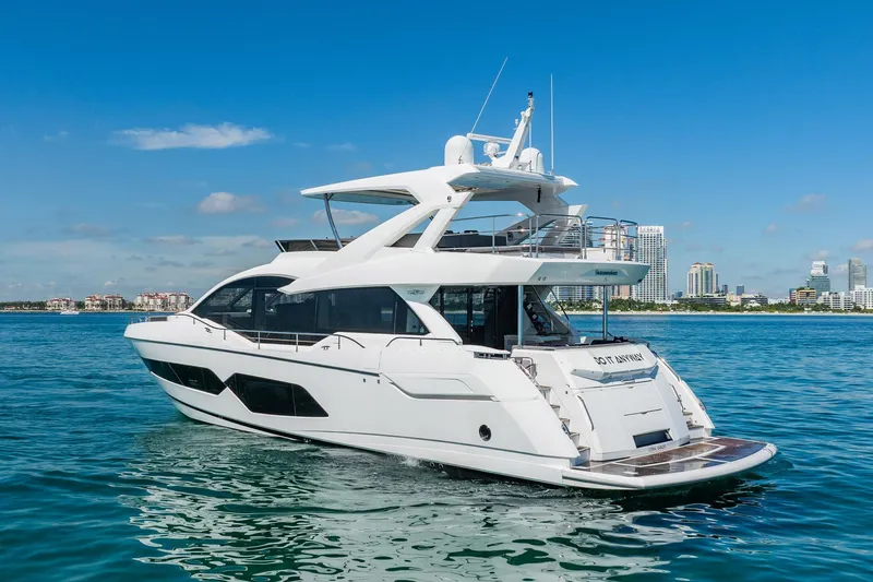 Do It Anyway Yacht Photos Pics 2018 Sunseeker 76 Yacht cruising on clear blue waters near city skyline.