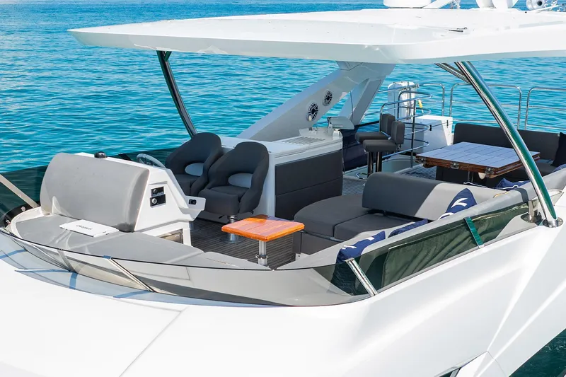 Do It Anyway Yacht Photos Pics Luxurious 2018 Sunseeker 76 Yacht with spacious deck and seating, cruising on clear blue waters.